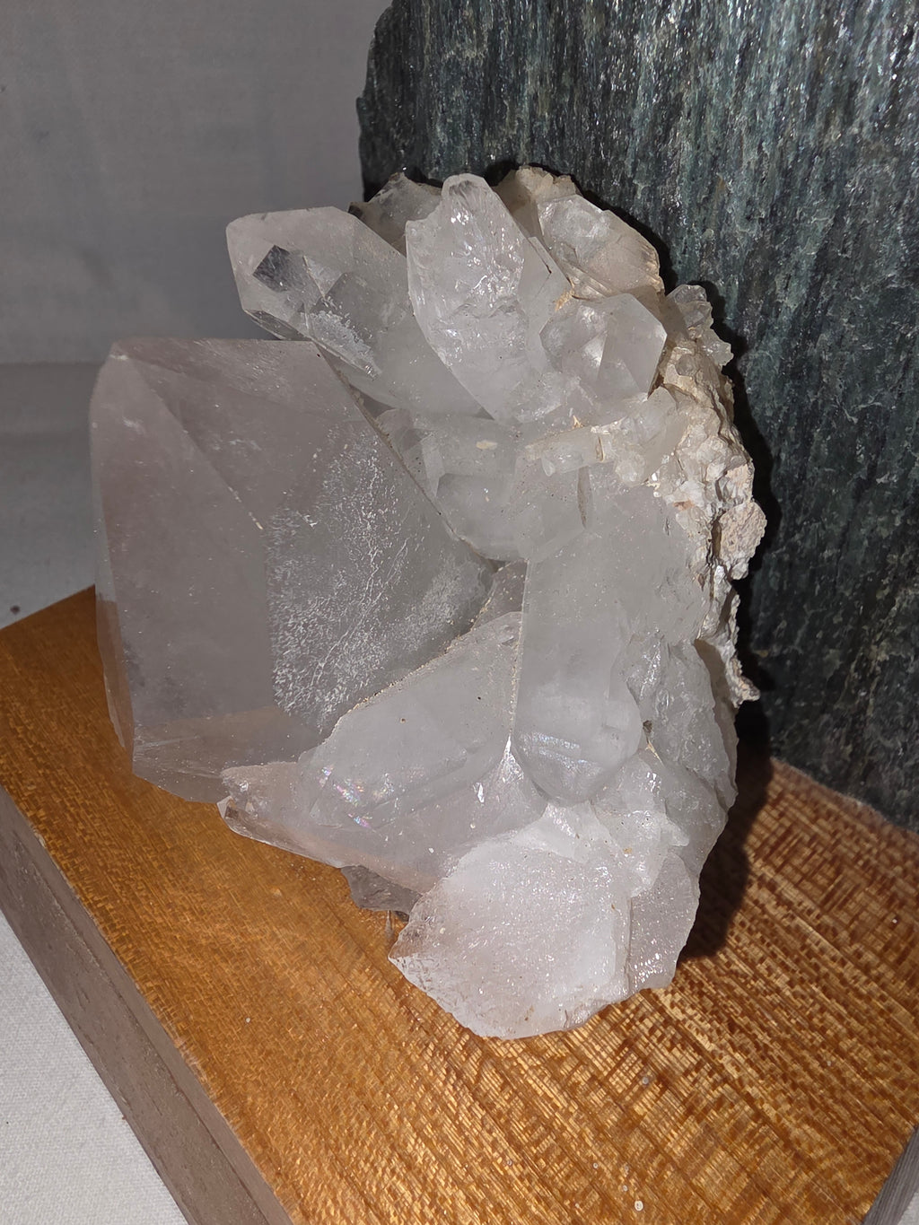 Dekoratives Mineralien-Arrangement mit Grünstein und Bergkristall auf Holzsockel