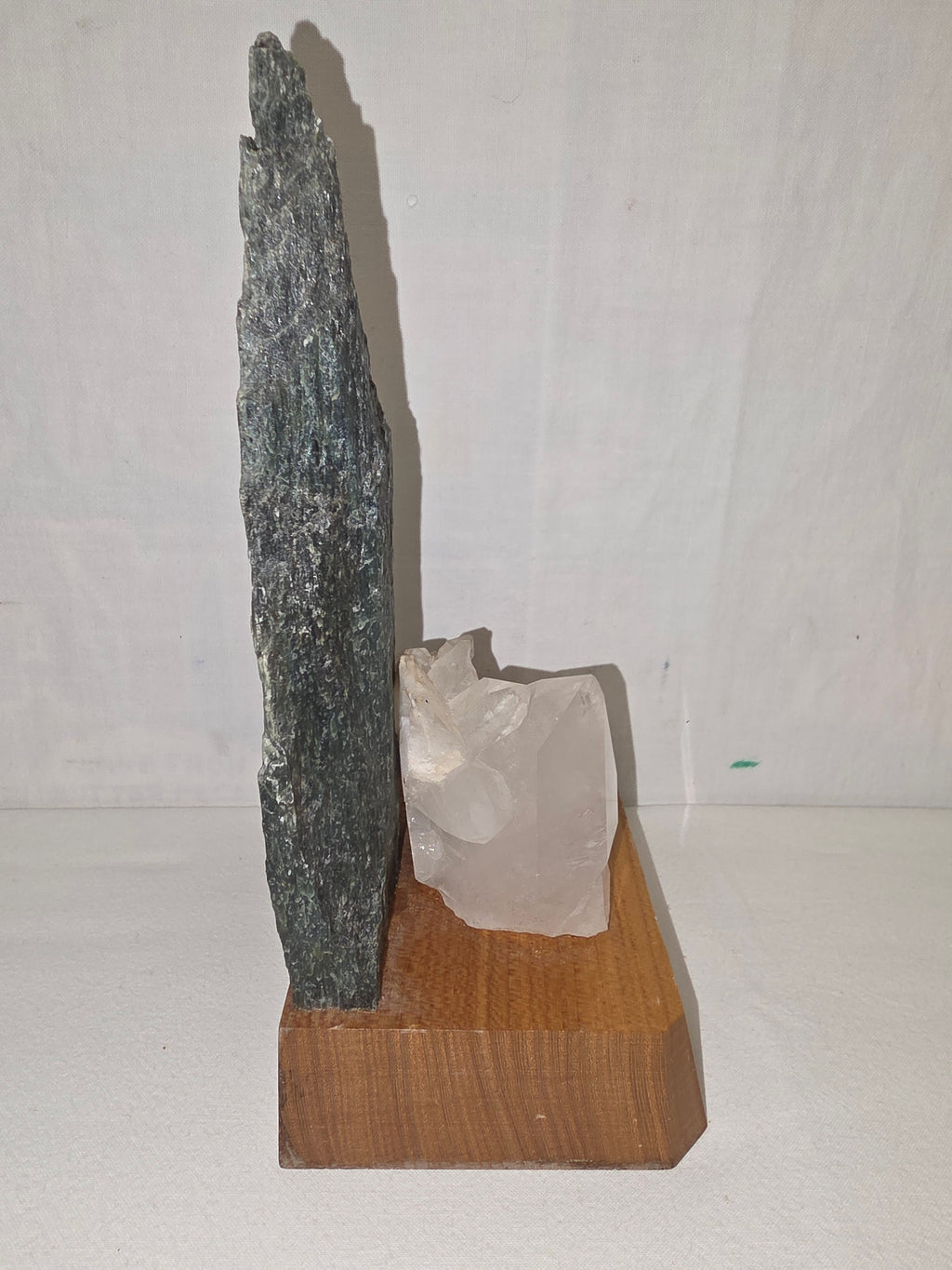 Dekoratives Mineralien-Arrangement mit Grünstein und Bergkristall auf Holzsockel