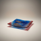 Strahlender Glasteller mit blauem und rotem Farbverlauf