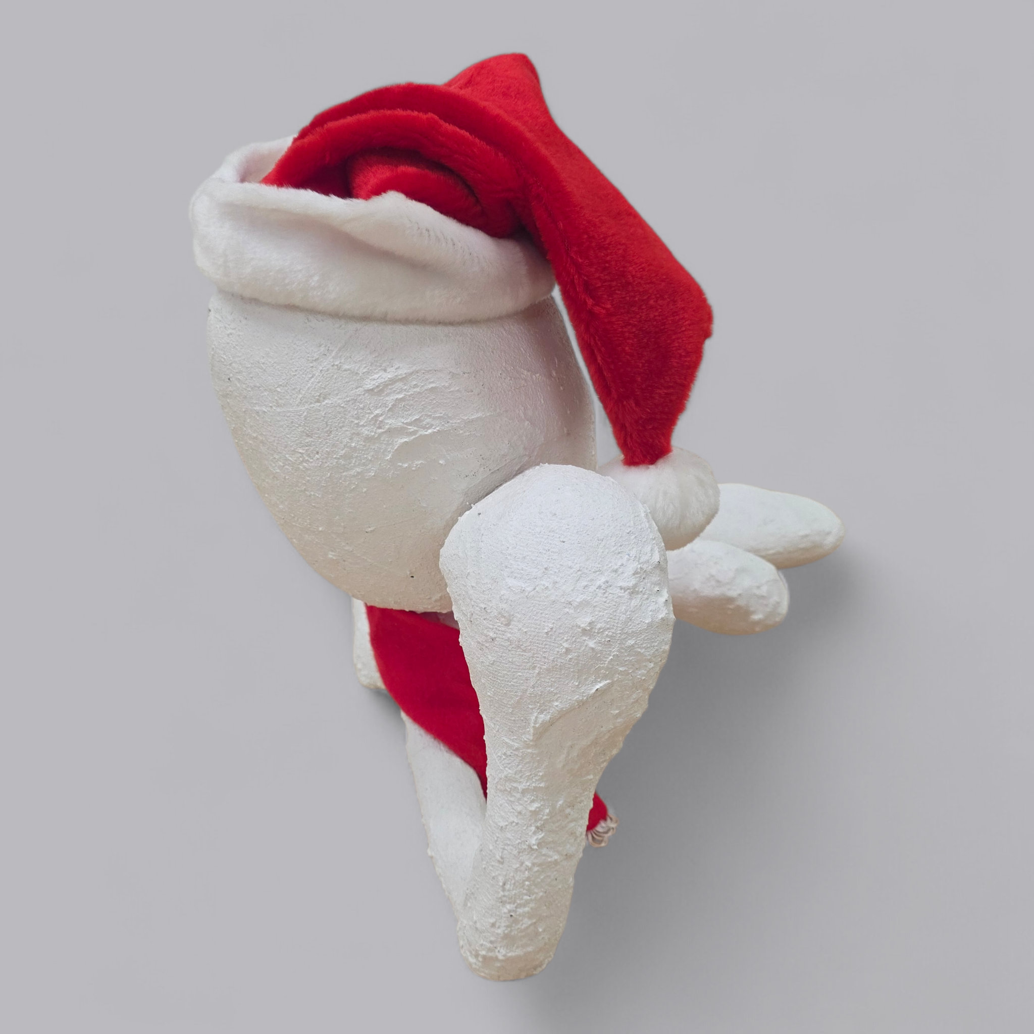 Abstrakte Gips-Skulptur – Sitzende Figur mit Weihnachtsmütze