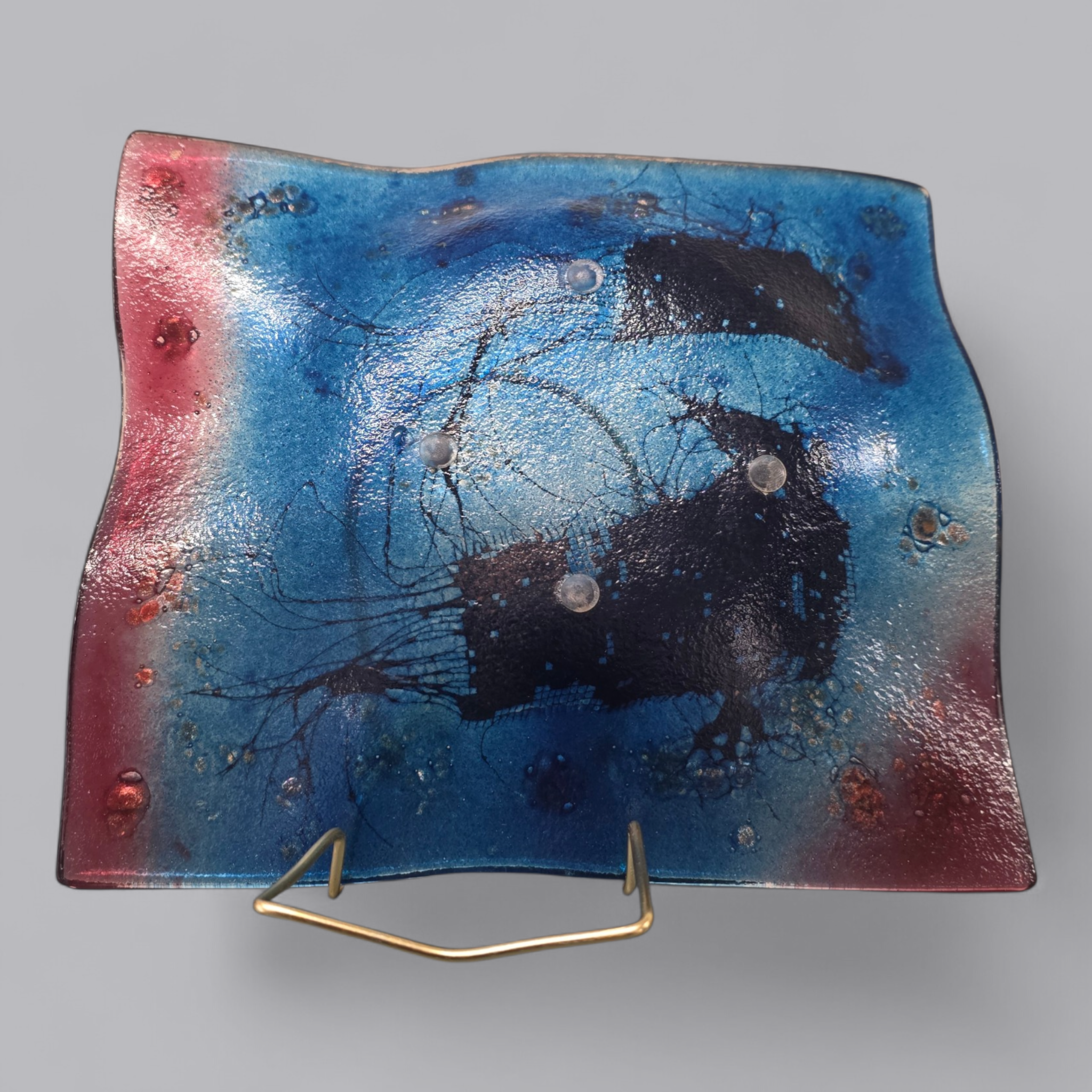 Strahlender Glasteller mit blauem und rotem Farbverlauf