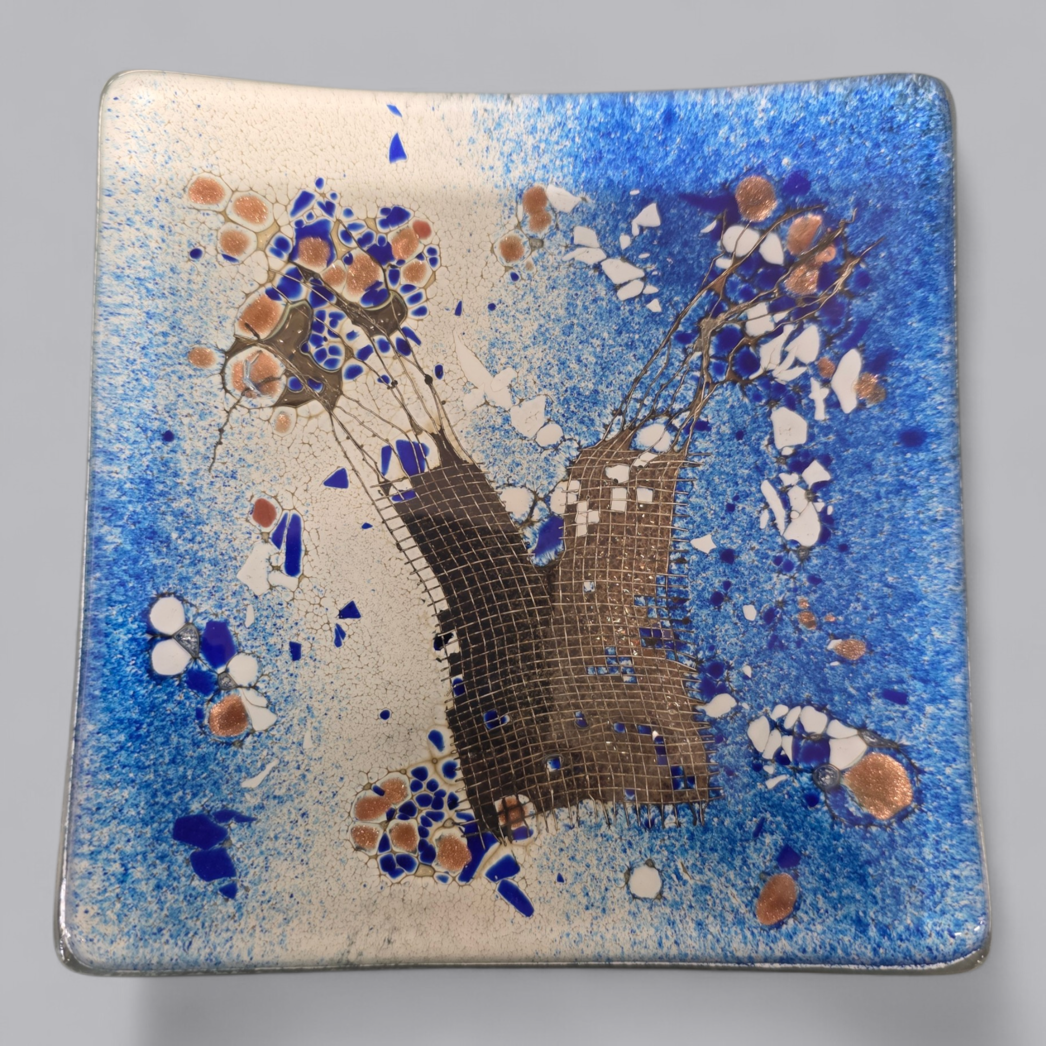 Blauer Glasteller mit kunstvollem Dekor