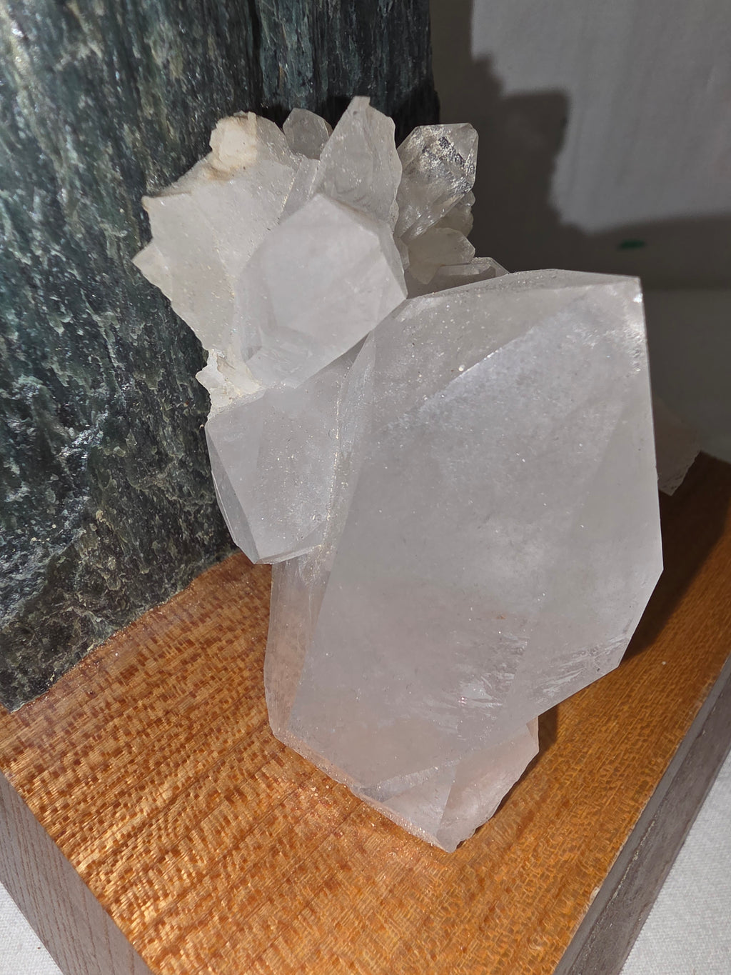 Dekoratives Mineralien-Arrangement mit Grünstein und Bergkristall auf Holzsockel