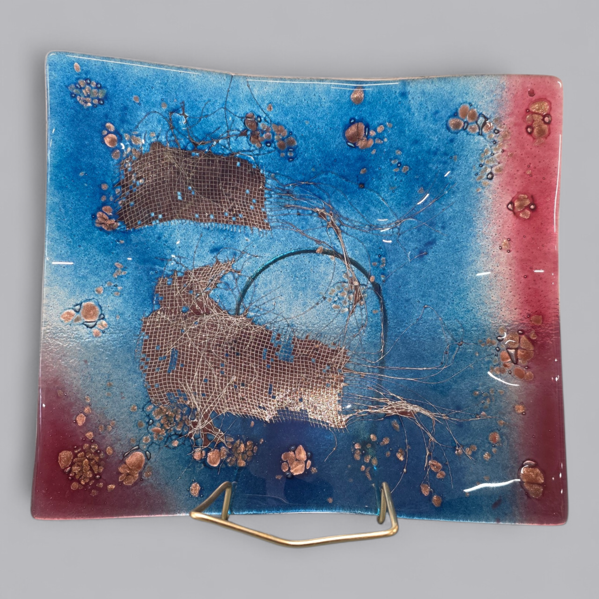 Strahlender Glasteller mit blauem und rotem Farbverlauf