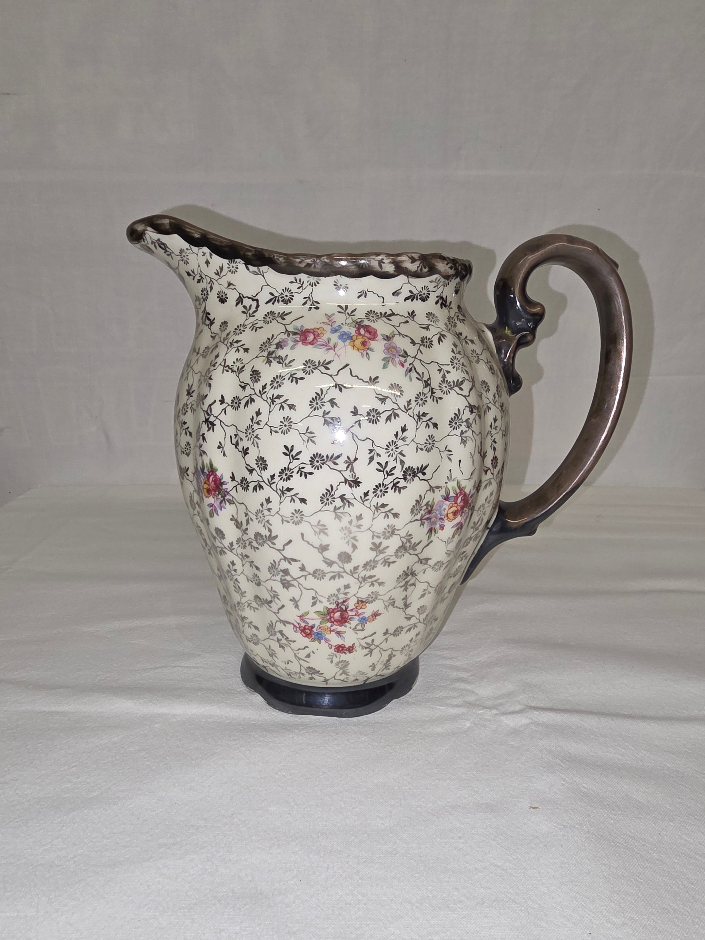 Edler Porzellankrug mit Feinsilber-Dekor und Blumenmuster