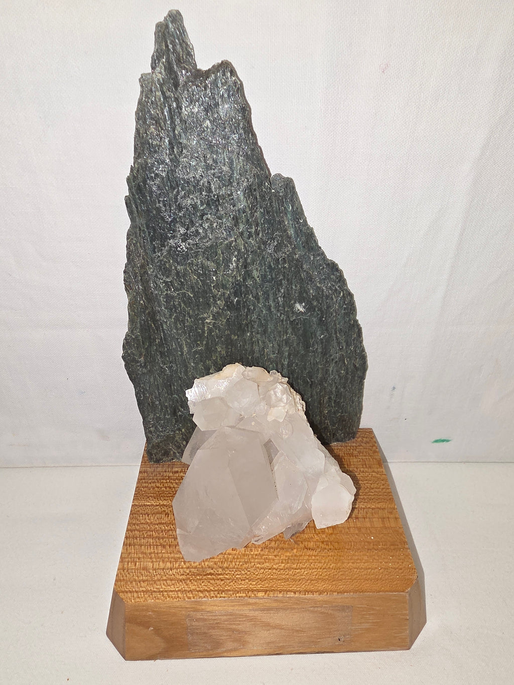 Dekoratives Mineralien-Arrangement mit Grünstein und Bergkristall auf Holzsockel