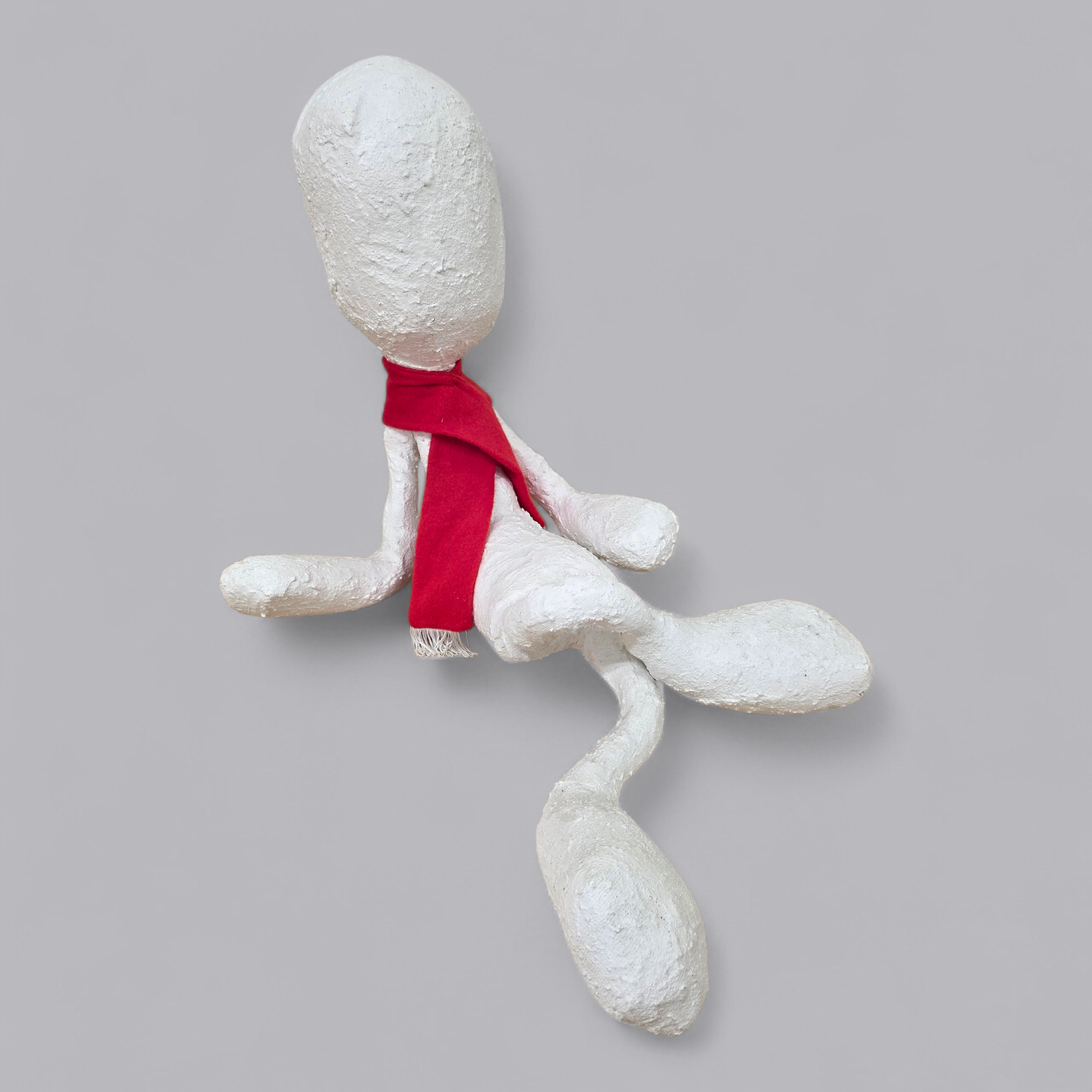 Abstrakte Skulptur – Sitzende Figur mit rotem Schal