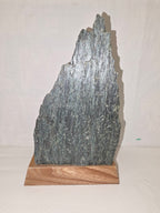 Dekoratives Mineralien-Arrangement mit Grünstein und Bergkristall auf Holzsockel